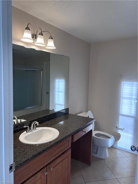 Full bathroom with vanity, a shower with door, and light tile patterned flooring