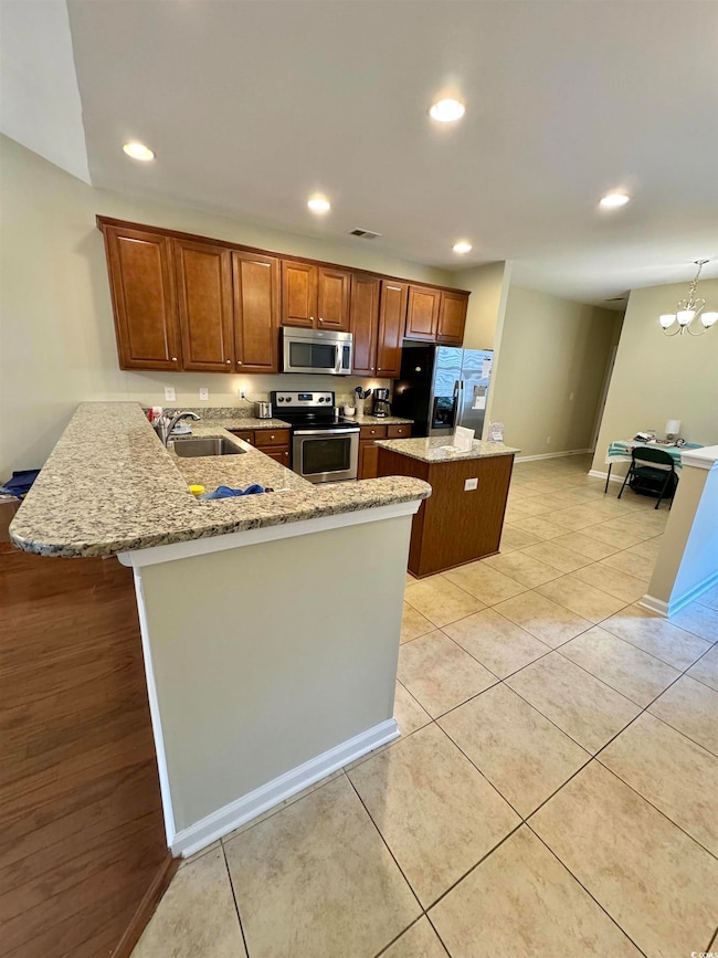Kitchen featuring kitchen peninsula, stainless ste