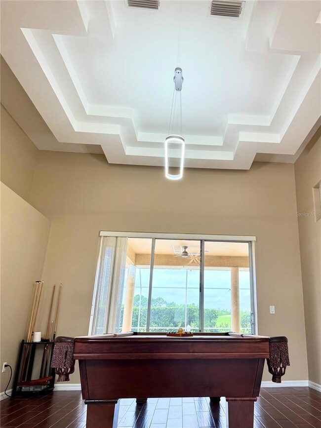 living room / game room with tray ceiling