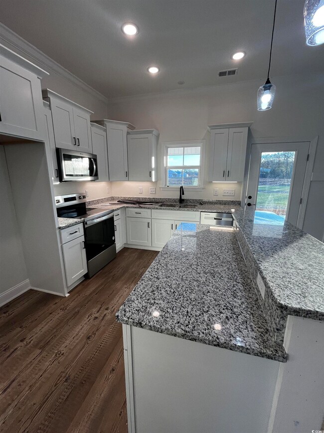 Kitchen with light stone countertops, white cabine