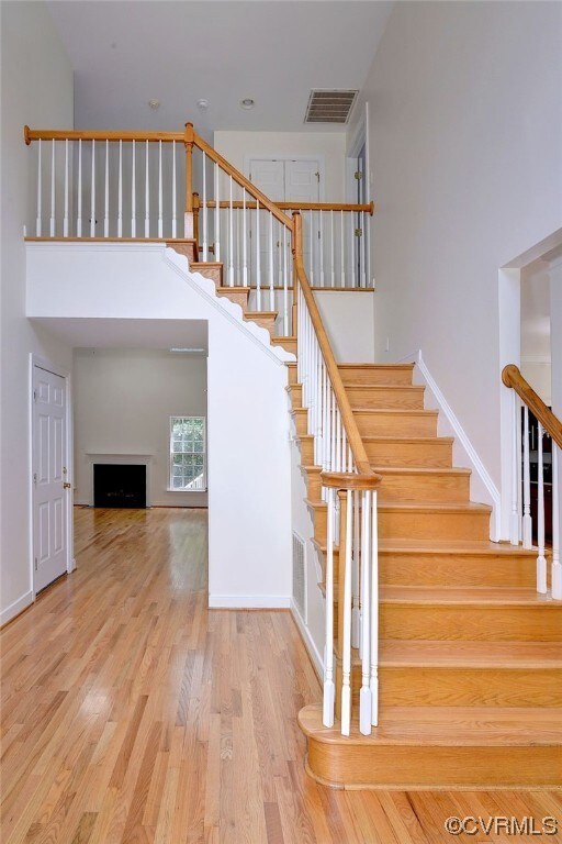 Staircase featuring a high ceiling and light hardw
