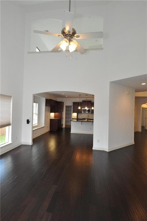 Unfurnished living room with a high ceiling, dark