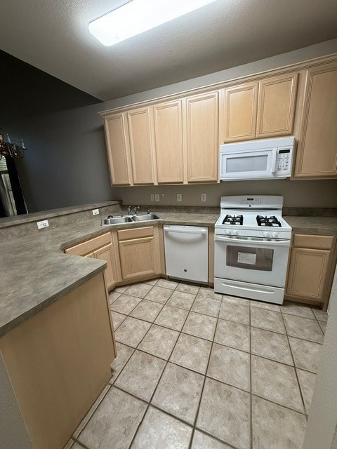 Kitchen featuring light brown cabinetry, stove, paneled dishwasher, light tile patterned floors, and a peninsula