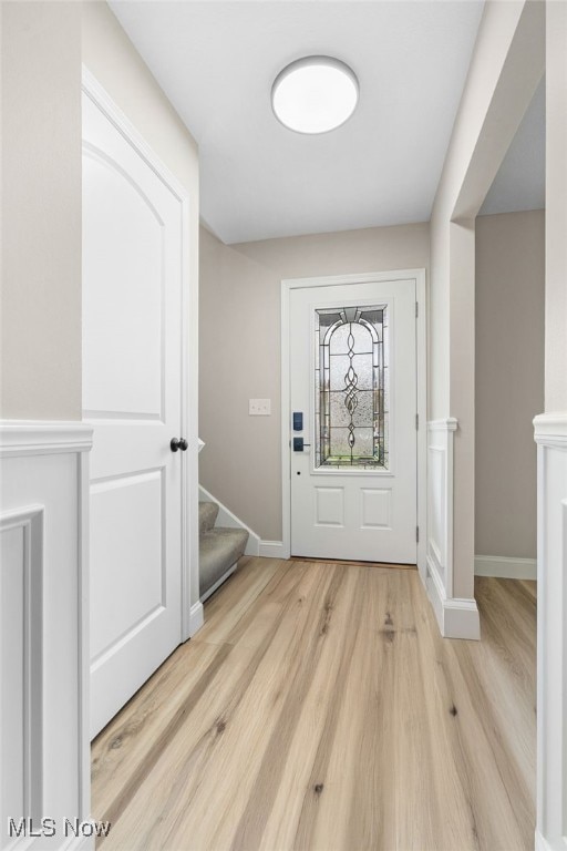 Foyer entrance featuring light wood-style floors and stairway