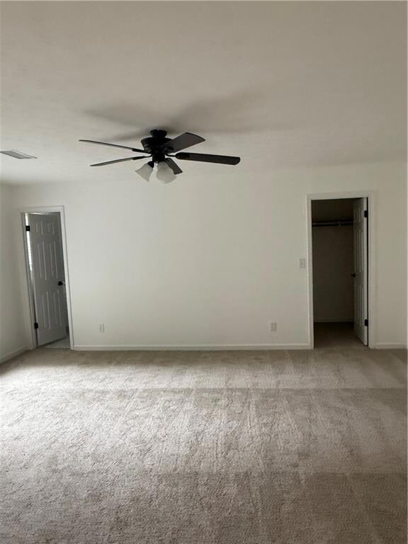 Spare room featuring light carpet and a ceiling fan