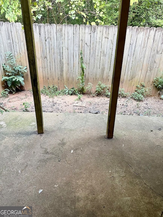 Private fenced-in patio area with wooded backdrop for added privacy and easy access from the living room.