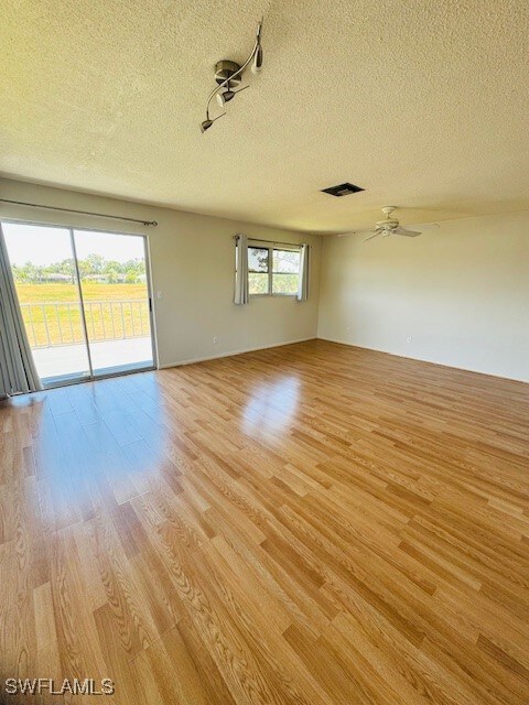 Empty room featuring a textured ceiling and light