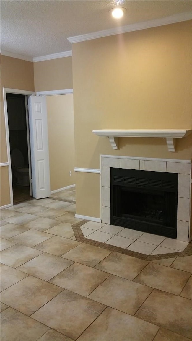 Interior Living Area details featuring a fireplace, neutral tile floors, and ornamental crown molding and chair rail