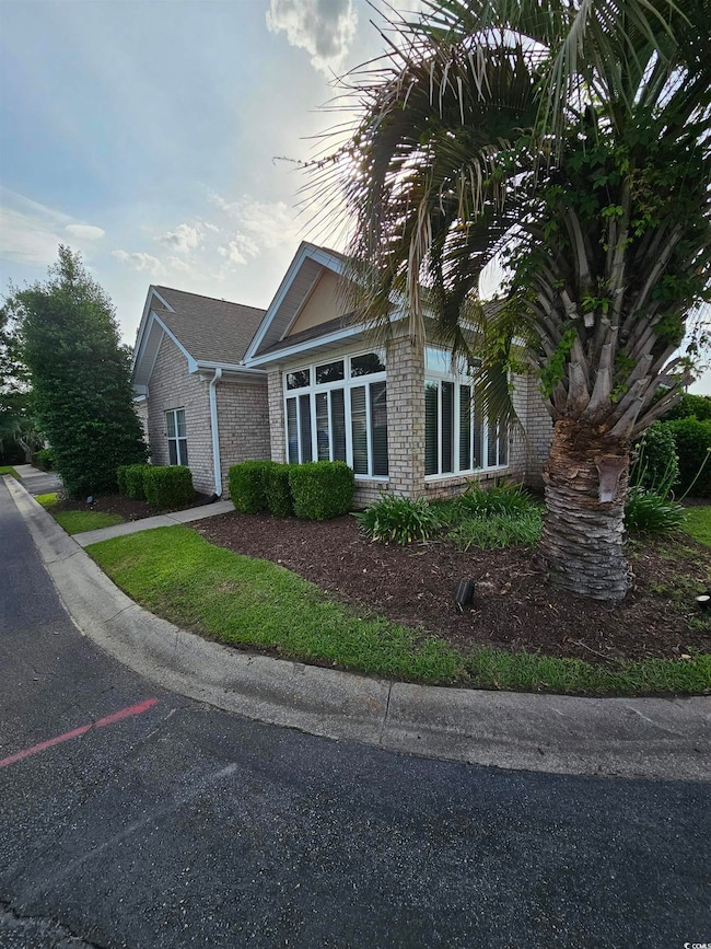 View of property exterior featuring brick siding and a sunroom