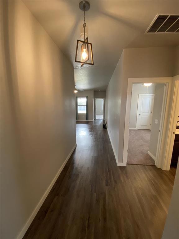 Hallway with dark wood-type flooring, visible vent