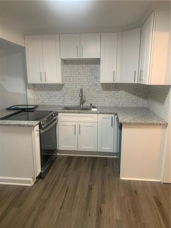 Kitchen featuring range, sink, dark hardwood / wood-style flooring, and white cabinetry.
