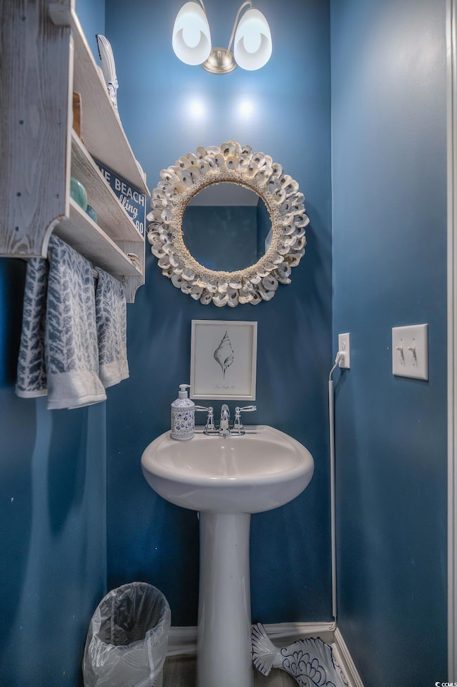Bathroom featuring baseboards and a sink