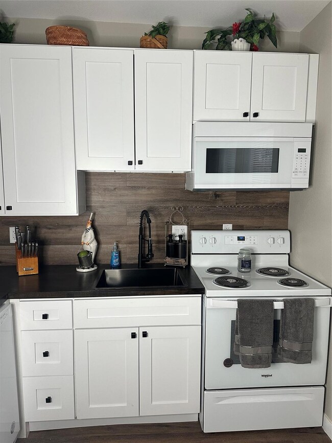 Kitchen featuring dishwasher, white cabinetry, sin