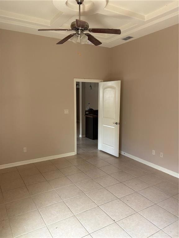 Empty room with a ceiling fan, light tile patterned flooring, and baseboards