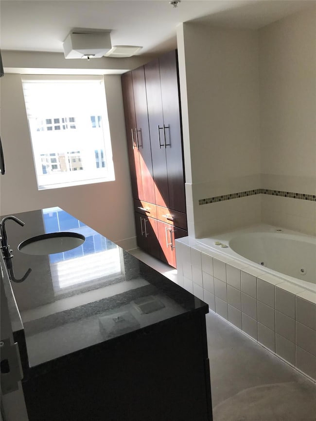 Full bathroom with a jetted tub and plenty of nat