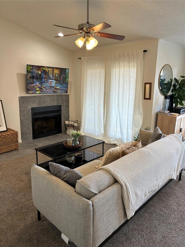 Living room featuring a tile fireplace, a textured
