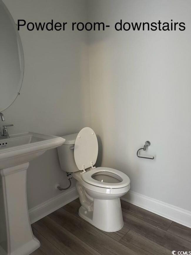 Bathroom featuring toilet, hardwood / wood-style f