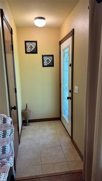 Entryway with light tile patterned flooring, baseboards, and healthy amount of natural light