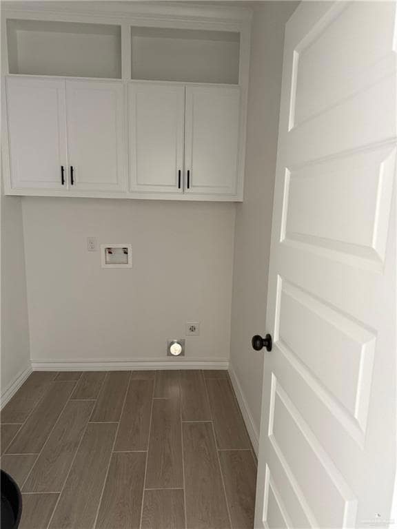 Laundry room with cabinet space, wood finish floors, hookup for a washing machine, and hookup for an electric dryer