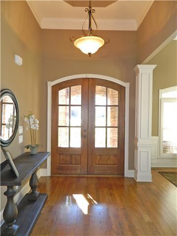 Spacious grand entry foyer with double   mahogany entry doors, hardwood flooring, and treyed ceiling.  