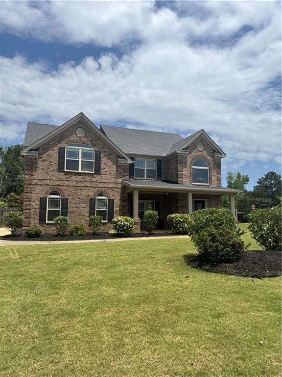 View of front of home featuring a front yard and brick siding