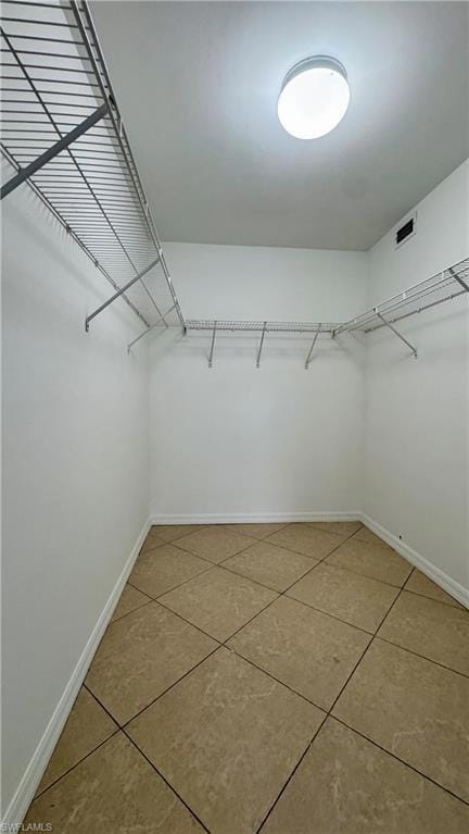 Walk in closet with tile patterned floors