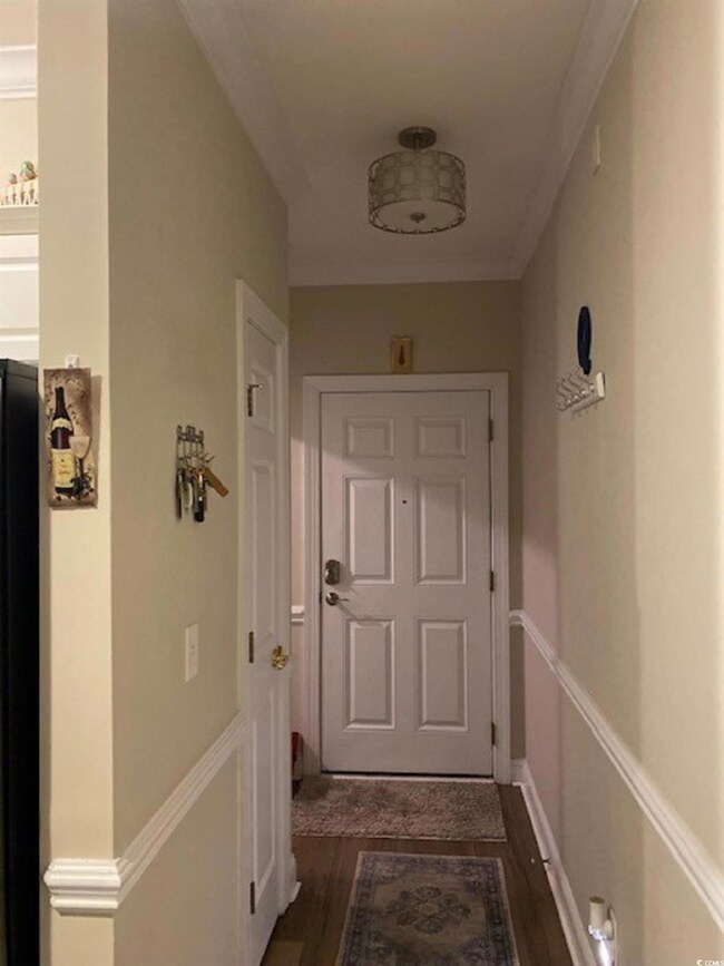 Entryway with baseboards, ornamental molding, and dark wood finished floors