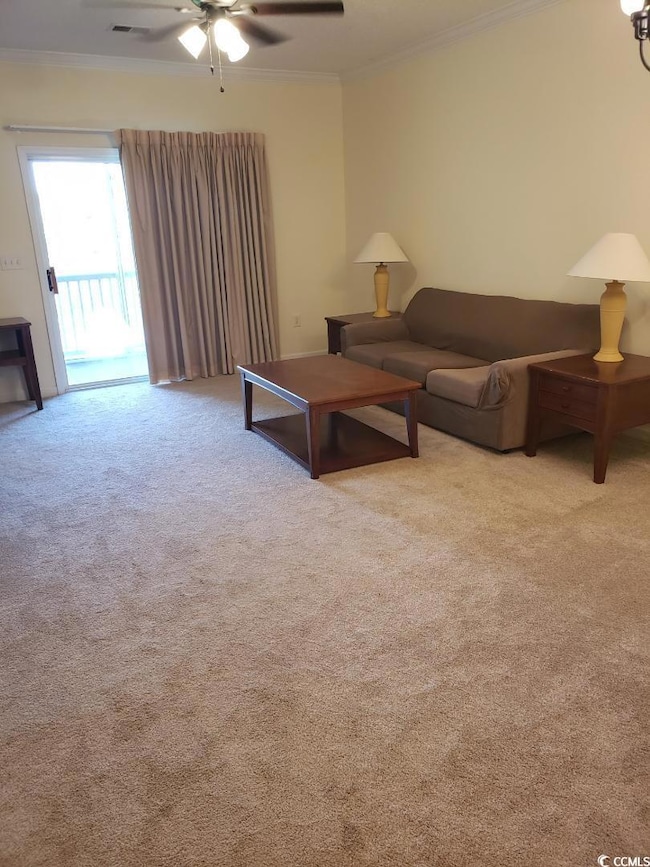 Living area with ceiling fan, ornamental molding, and carpet