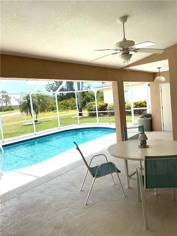 Outdoor pool featuring a patio area, ceiling fan, a lanai, and a lawn