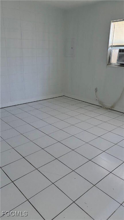 Unfurnished room featuring light tile patterned flooring and electric panel