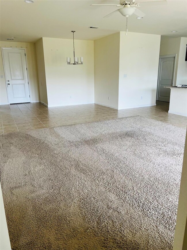 Tiled spare room featuring a ceiling fan and a ch