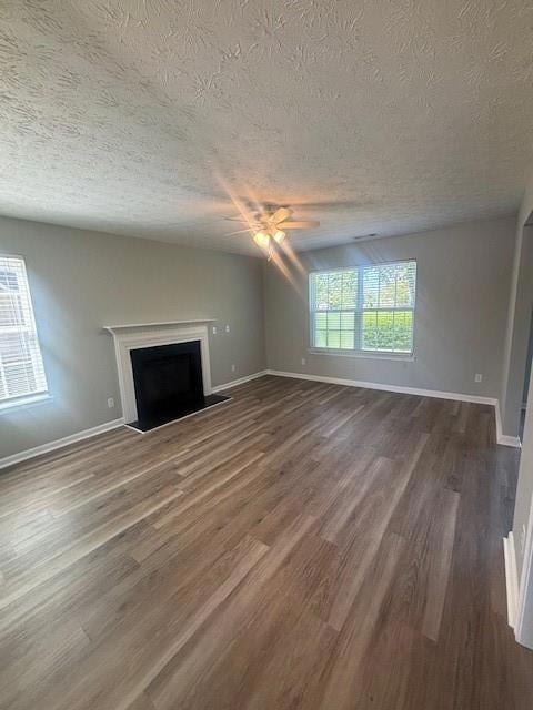 Unfurnished living room featuring ceiling fan, a f