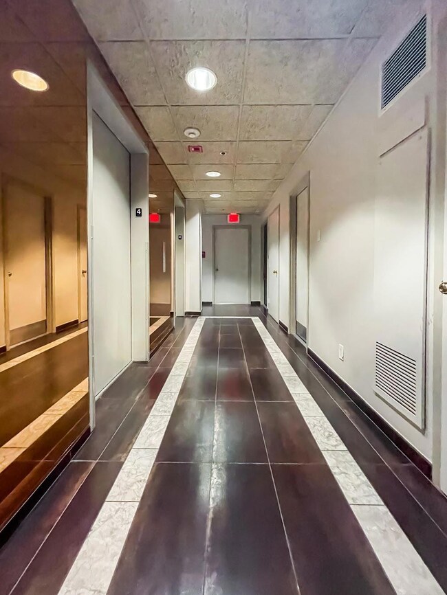 Corridor with recessed lighting, tile patterned f