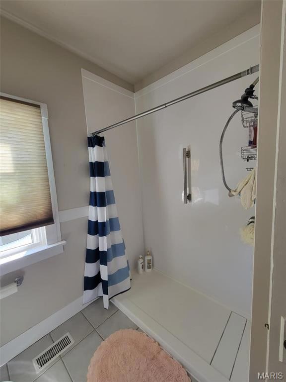 Bathroom featuring tile patterned flooring, visible vents, and curtained shower