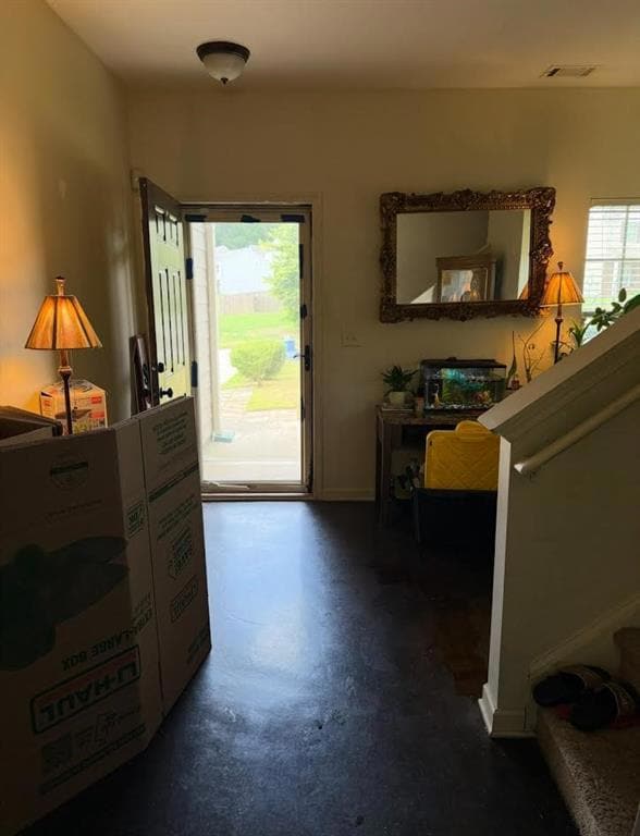 Entryway with finished concrete flooring and baseboards