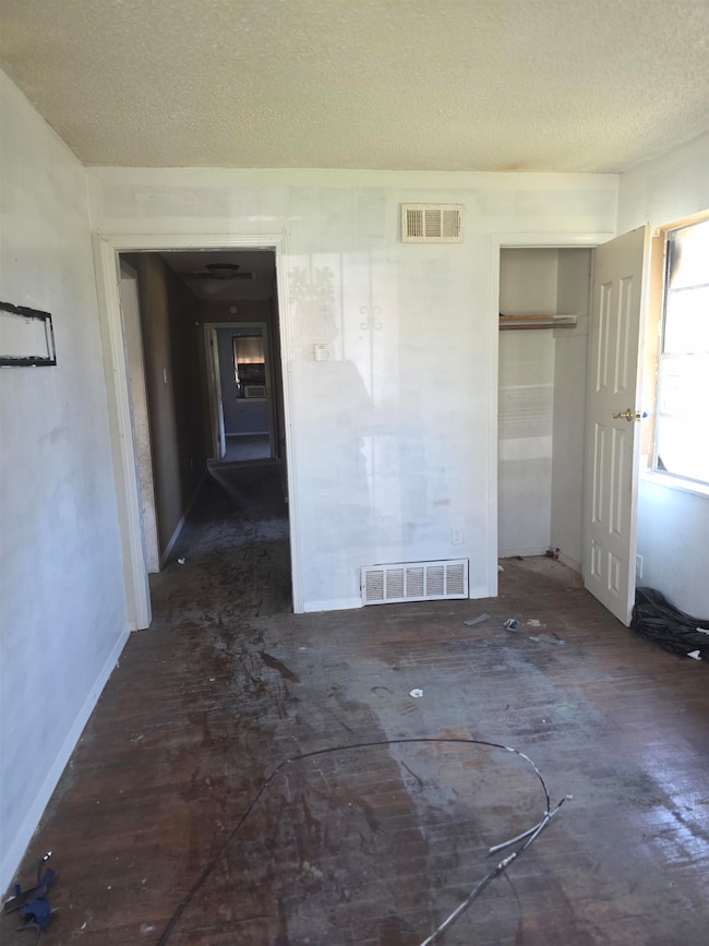 Unfurnished room featuring visible vents and a tex