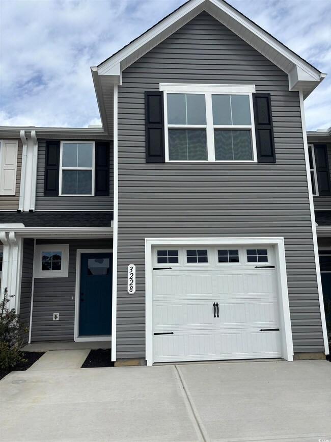 View of front facade featuring a garage and concre