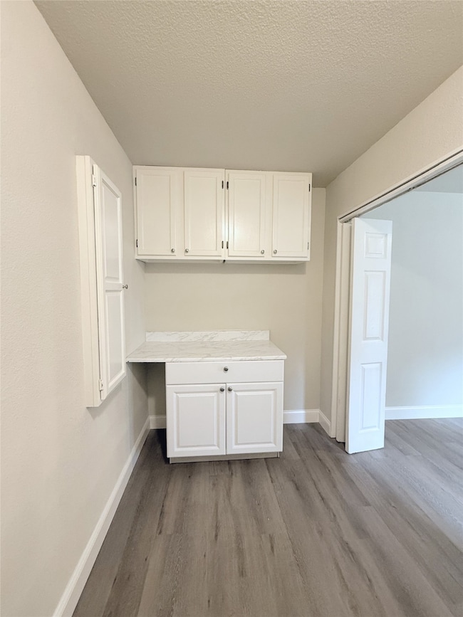 Washroom featuring a textured ceiling and dark wood-type flooring
