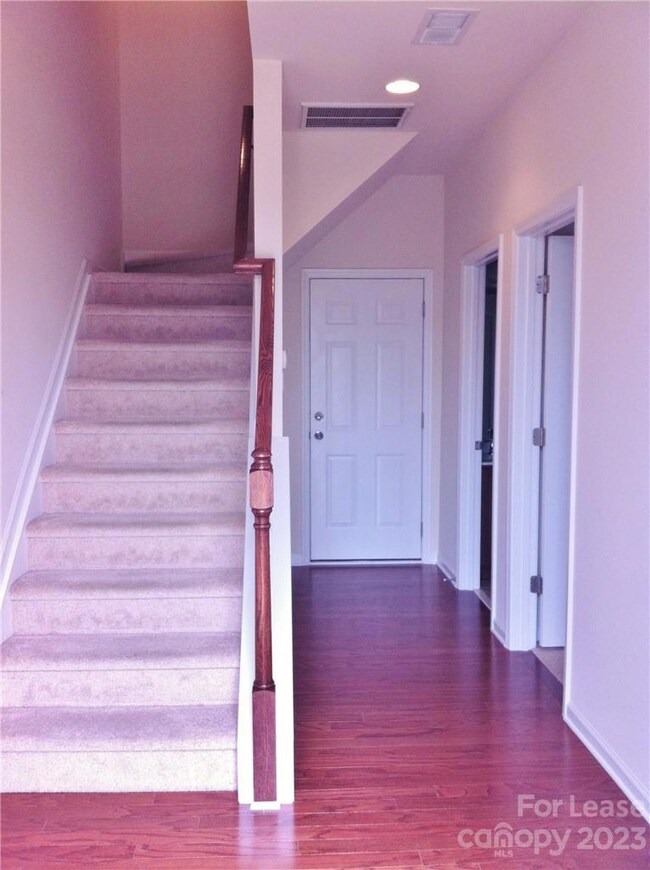 View of entrance hall with bedroom and full bath to the right and entrance to garage at the end of the hall.  Stairs lead to main level.