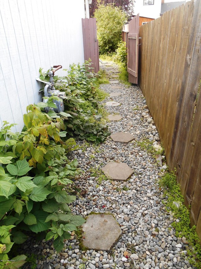 Paved, rocked walkway along N side house