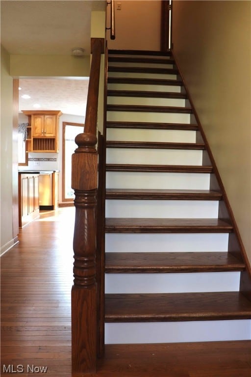 Staircase with light hardwood / wood-style flooring