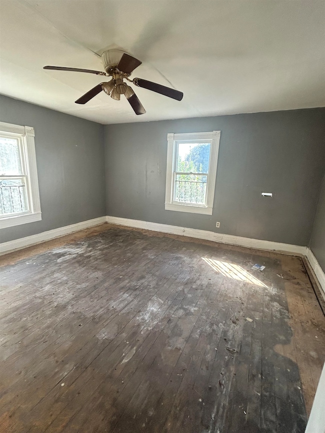 Spare room with baseboards and hardwood / wood-style flooring