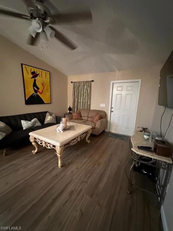 Living room with ceiling fan, vaulted ceiling, and