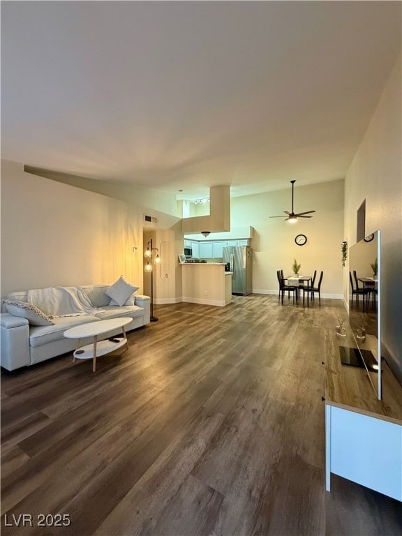 Unfurnished living room with dark wood finished floors and baseboards