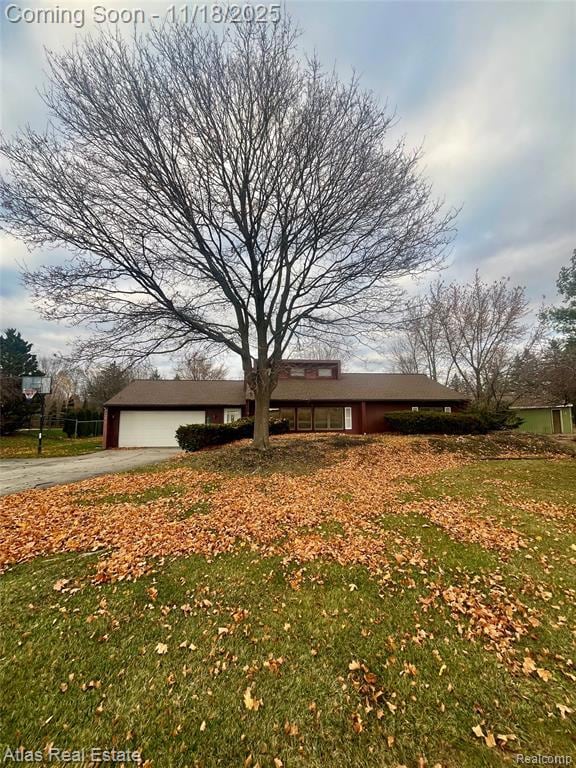 Ranch-style house with a front lawn, driveway, and an attached garage