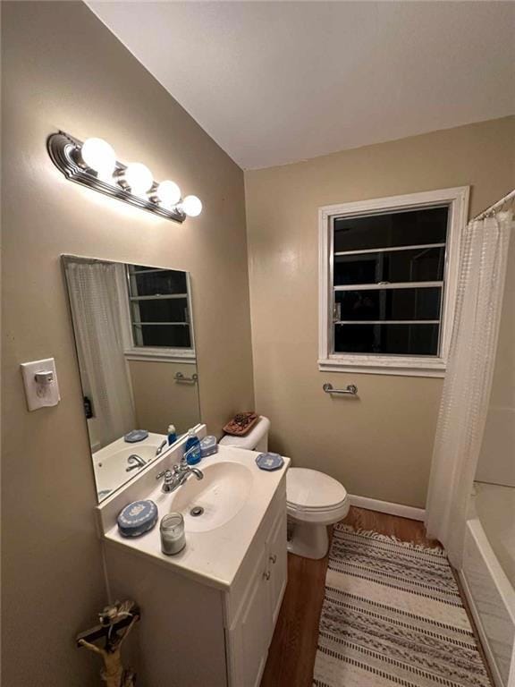 Bathroom featuring wood finished floors, vanity, and shower / tub combo