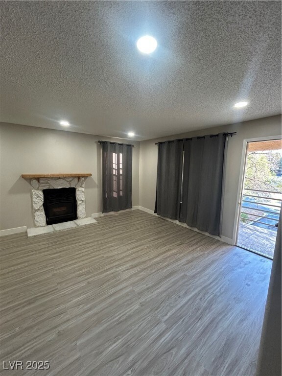 Unfurnished living room featuring baseboards, a te