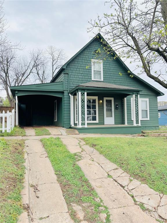 View of front facade with covered porch, a carport, and driveway