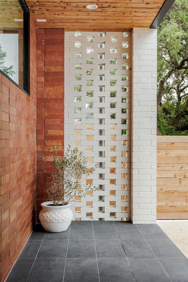 Exterior details featuring brick siding and fence