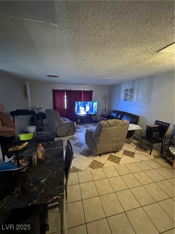 Living area with a textured ceiling and light tile patterned floors